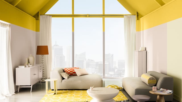 Modern living room with yellow walls, sofas, a rug, and a view of the city skyline