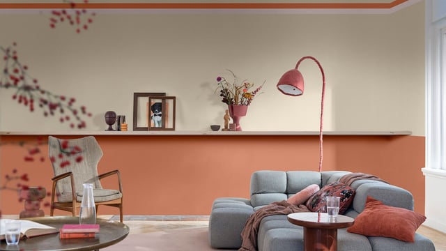 Living room with a beige-pink wall, blue sofa, and decorative cushions