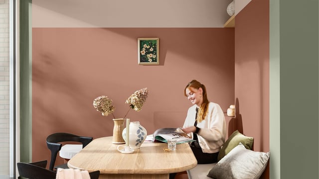 Woman seated at a desk in a cozy home office, reading by warm light