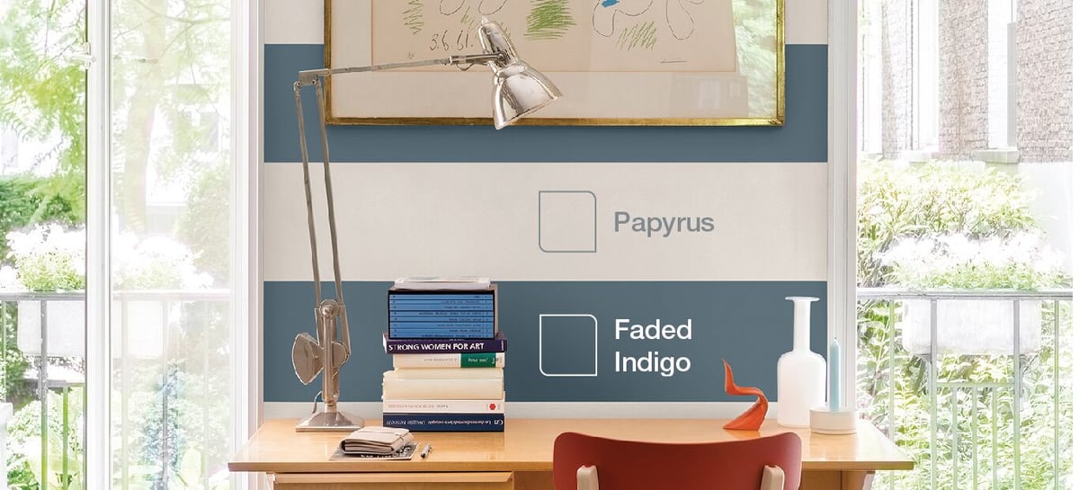 Office desk with lamp and books, with colour names “Papyrus” and “Faded Indigo” on the wall