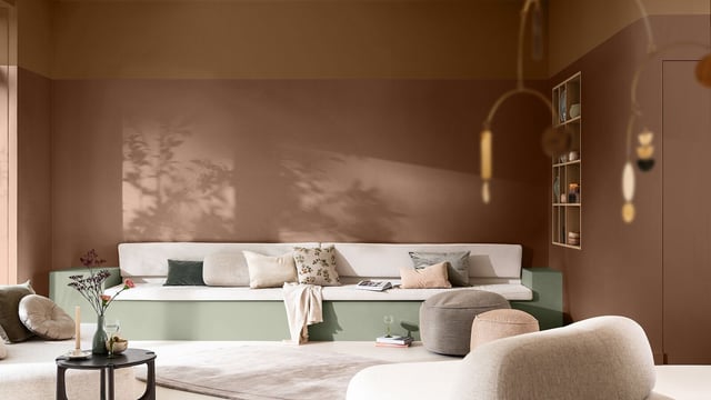 Cozy living room with neutral sectional sofa, patterned pillows, coffee table, and warm ambient lighting