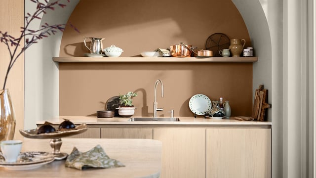 Warm, modern kitchen built-in shelves with cookware and a sink, lit by soft ambient light