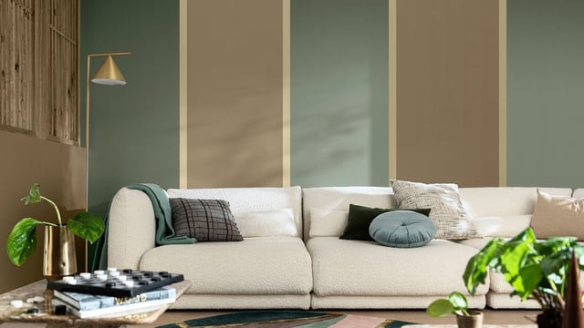 Living room with a cream sofa, green cushions and a table lamp