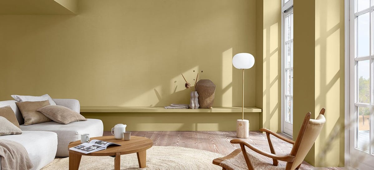 Bright living room with sofa, wooden coffee table, floor lamp, and large windows