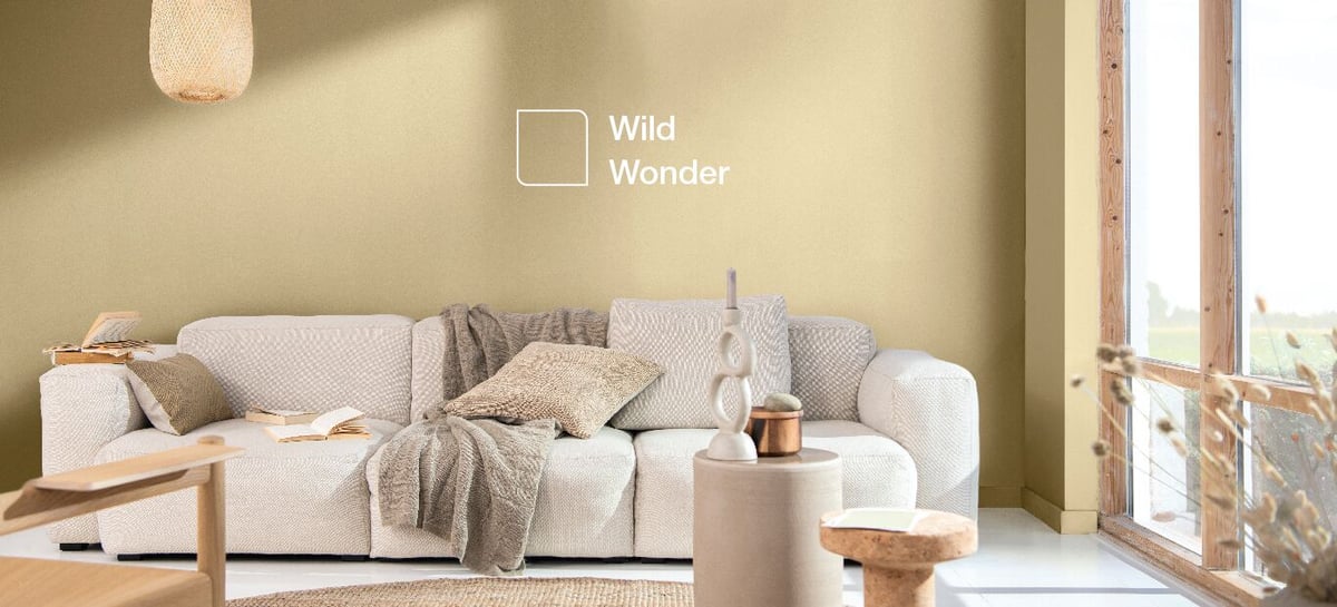 Living room interior with sofa and lamps, with “Wild Wonder” logo on the wall