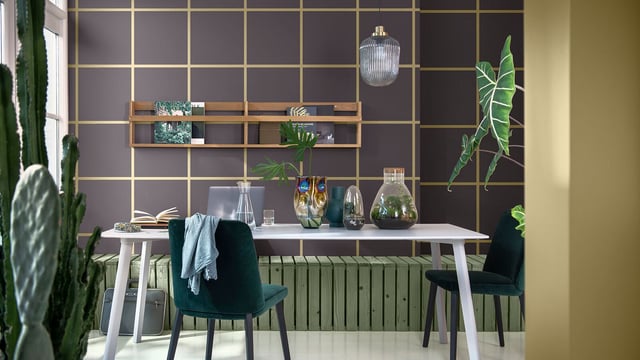 Stylish home office interior with white table, green chairs, shelves, gold grid wall and plants