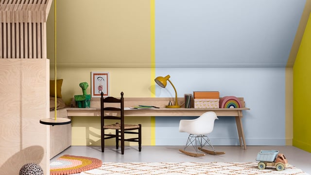 Bright home office corner with desk, chair, shelves, lamp and patterned rug