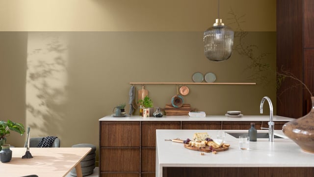 Modern kitchen interior with dark wood units, light worktops, and a pendant light over the island